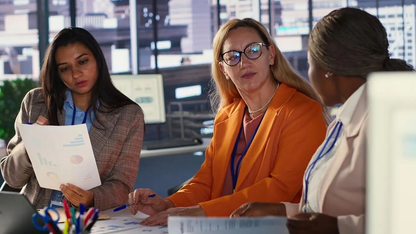 Амбициозные женщины-руководители работают сообща в разнообразной рабочей среде.