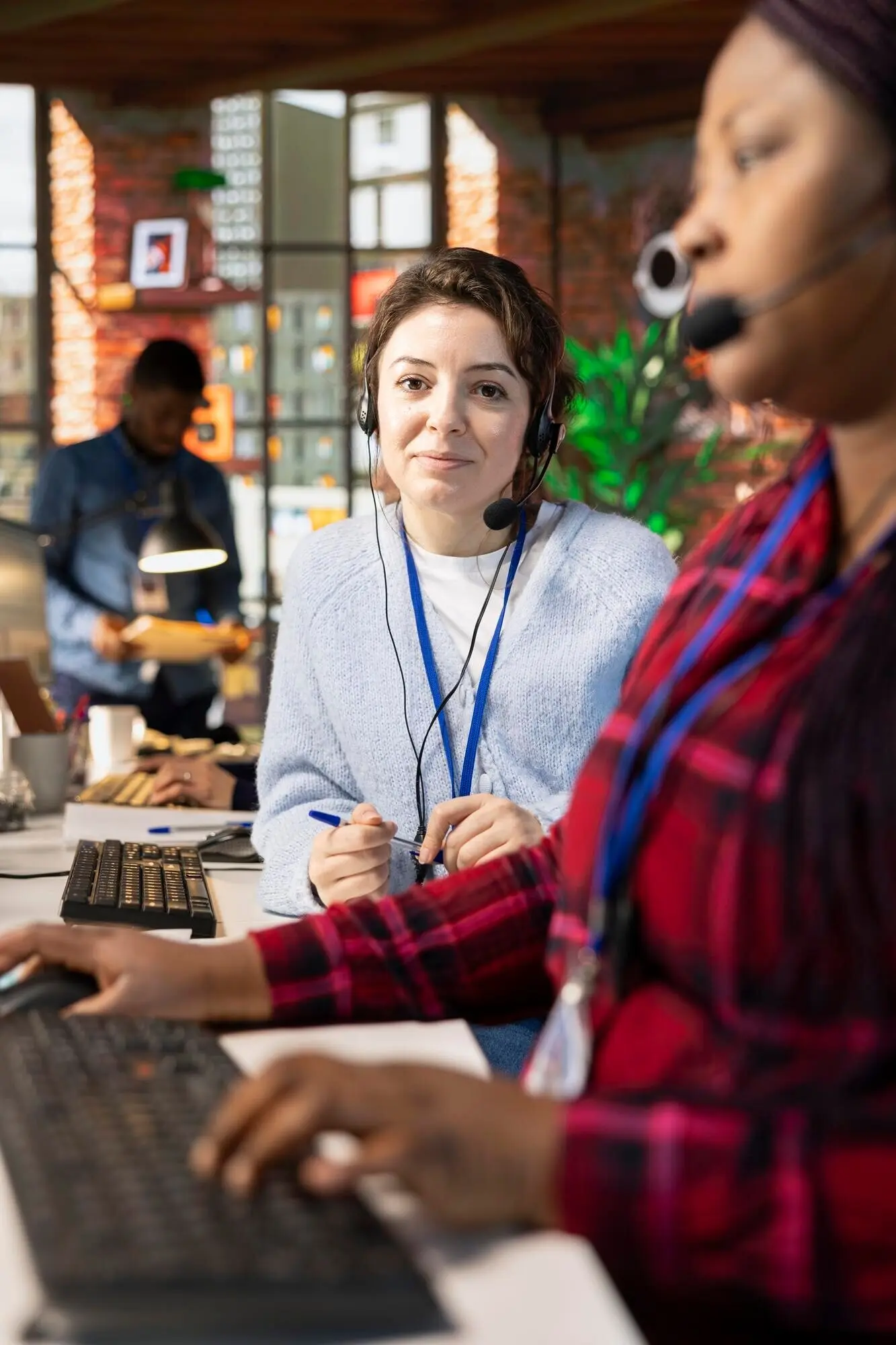 Портрет улыбающегося специалиста по онбордингу колл-центра, обучающего нового рекрута.